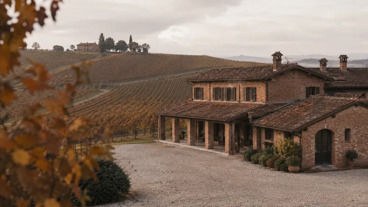 Casa colonica in Piemonte circondata dai filari di vigne autunnali